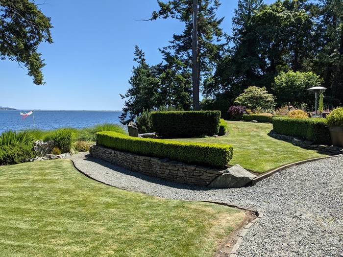 Stone-walled estate garden with shaped boxwood and lawn