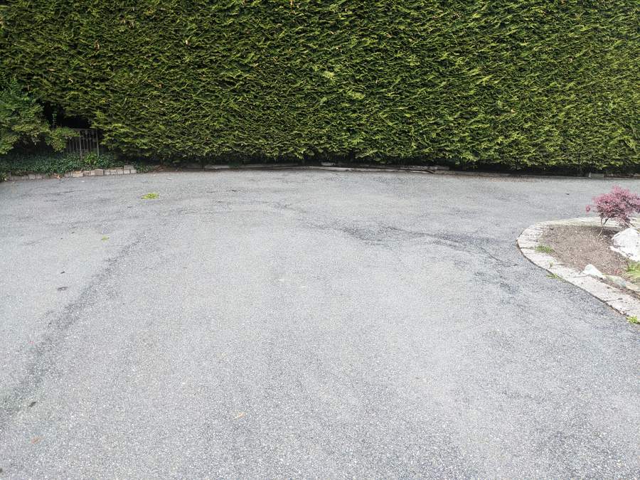 A driveway showing clean concrete after pressure washing